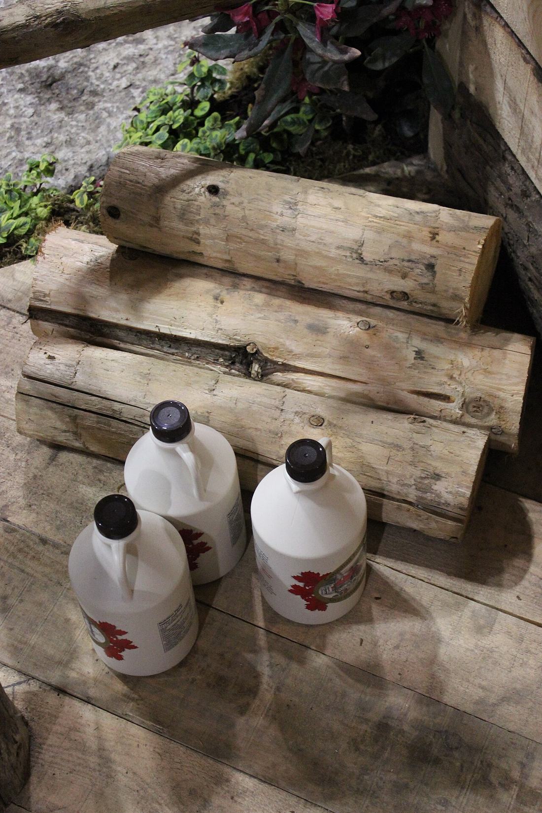 Maple syrup bottles and logs in Ontario